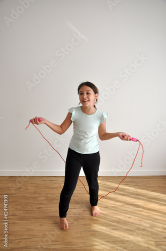 criança pré adolescente aptidãop exercicios fisícos com corda em ginásio, treino de pular corda  photo