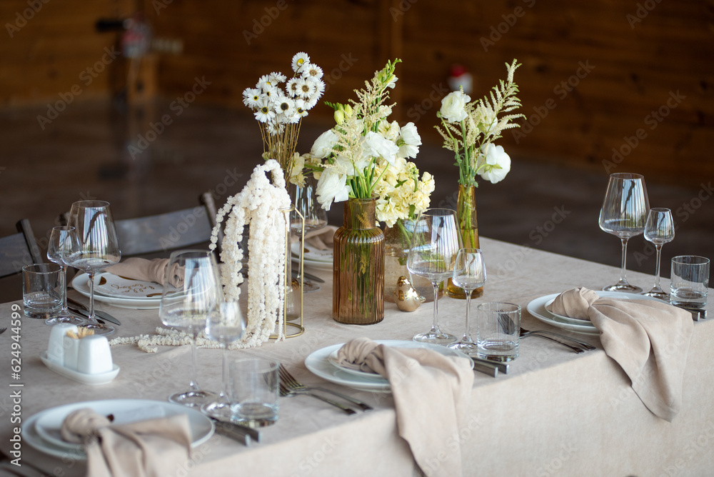beautiful table setting with flowers and cutlery on wooden table at wedding or dinner. stylish tablewear decorations