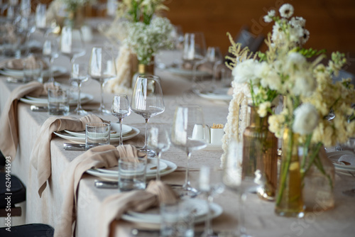 beautiful table setting with flowers and cutlery on wooden table at wedding or dinner. stylish tablewear decorations photo