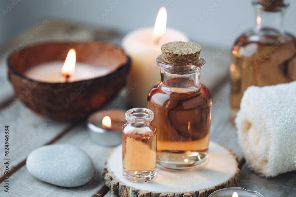 Concept of spa treatment in salon with pure organic natural oil. Atmosphere of relax, detention. Aromatherapy, candles, towel, wooden background. Skin care, body gentle treatment Concept of spa treatment in salon with pure organic natural oil. Atmosphere of relax, detention. Aromatherapy, candles, towel, wooden background. Skin care, body gentle treatment
