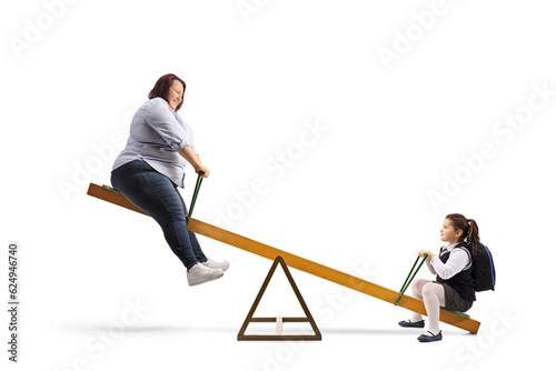 Corpulent woman playing on a seesaw with a schoogirl
