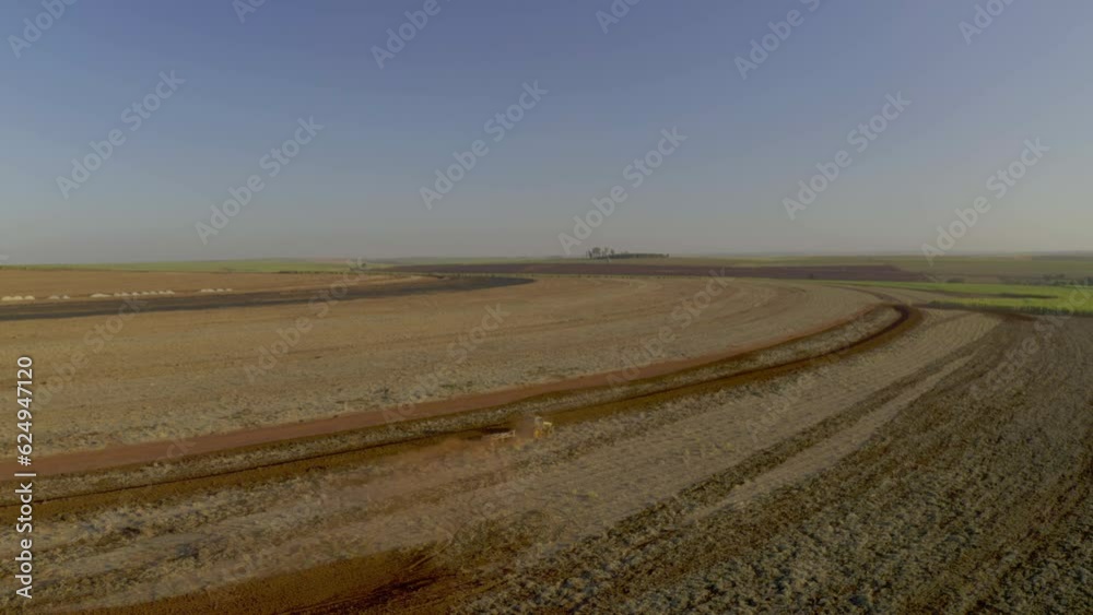 tractor plowing and mixing products to the ground for future sugarcane plantation at sunset tractor plowing and mixing products to the ground for future sugarcane plantation at sunset