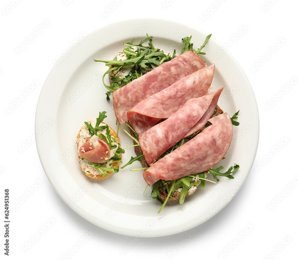 Tasty ham and jamon bruschettas with arugula on white background