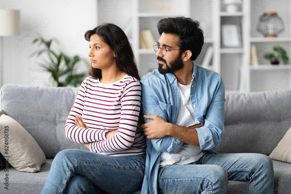 Young indian man looking at his offended girlfriend or wife Young indian man looking at his offended girlfriend or wife