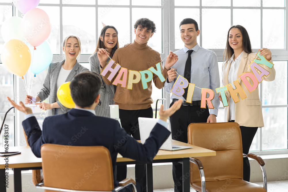 Obraz premium Group of business people greeting their colleague at birthday party in office