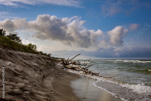 Beautiful holiday landscape by the Polish Baltic Sea. Sandy beach and clouds on a blue background in a holiday concept.