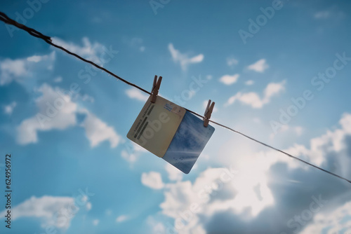 old postcards or notes dry on a clothesline on clothespins against the blue sky. Generative AI