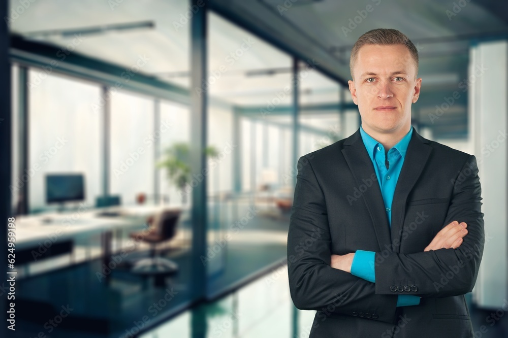 Young happy business man with arms crossed at office Young happy business man with arms crossed at office