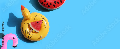 Watermelon slice popsicle on inflatable of yellow duck on blue background. Summer background concept