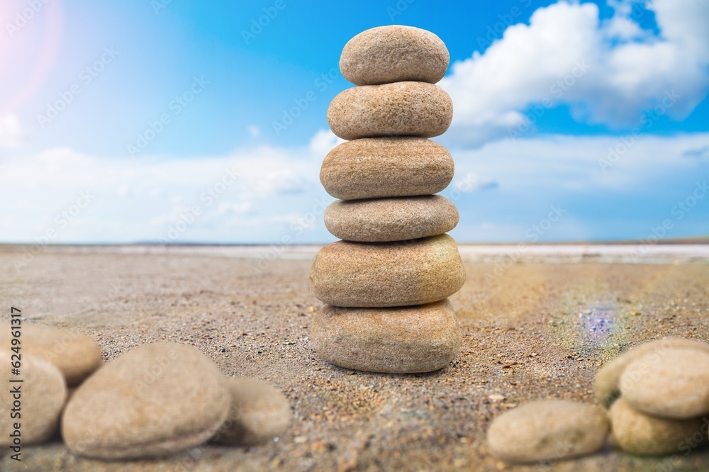 Balance stone on the beach sand and sky background Balance stone on the beach sand and sky background