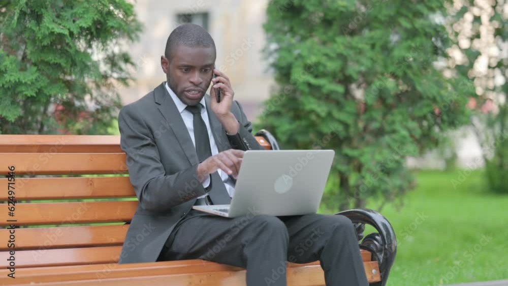 African Businessman Talking on Phone at work