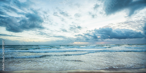 Horizonte do mar em praia deserta de Taipu de Fora, no litoral da Bahia, no nordeste Brasileiro. Densas nuvens em céu colorido no amanhecer do dia. 