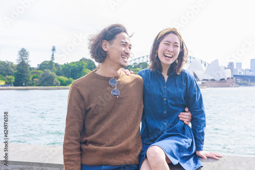 オペラハウスの前で微笑み合う日本人カップル