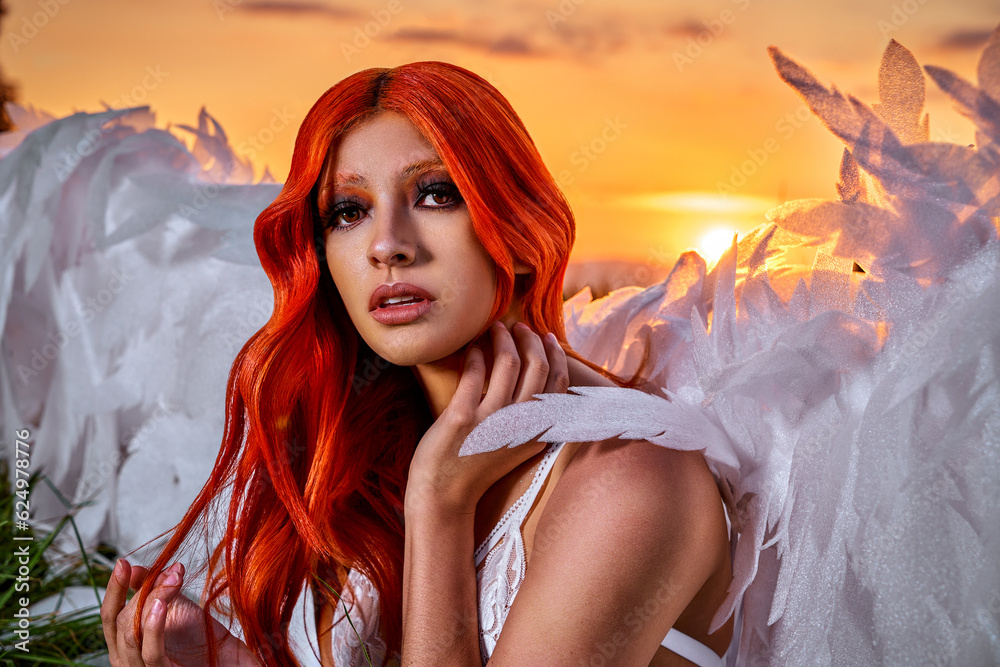 sexy angel wings. woman sitting in meadow with giant angel wings