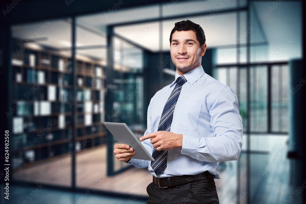 Handsome young businessman works on digital tablet Handsome young businessman works on digital tablet