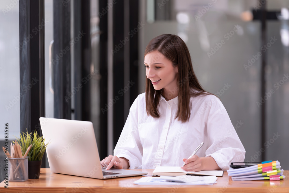 Businesswoman working in front of a laptop in the office. Businesswoman working in front of a laptop in the office.