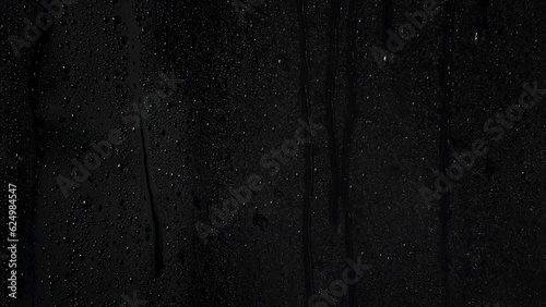 Water drops running on a wet window with light mist