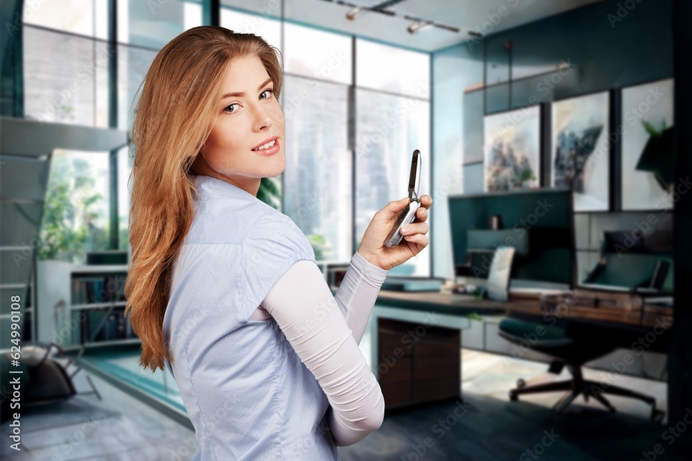 Young happy businesswoman using smartphone