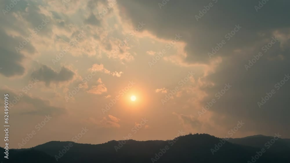 Time lapse of the sun setting over hills that are covered with clouds, in the style of smokey background. Time lapse of the sun setting over hills that are covered with clouds, in the style of smokey background.