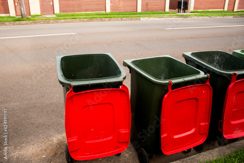 Australian garbage wheelie bins with colourful lids for general and recycling household waste on the street kerbside for council rubbish collection.