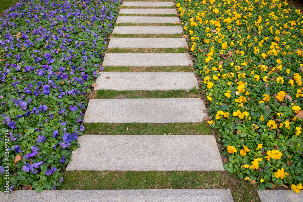 Brick walkway and yelow and violet folwer lawn in perspective view
