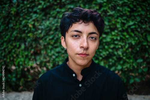Close-up view of a transgender person posing on natural background.