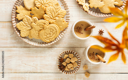 Autumn table scene with spiced halloween cookies. Top view on a rustic wood background.