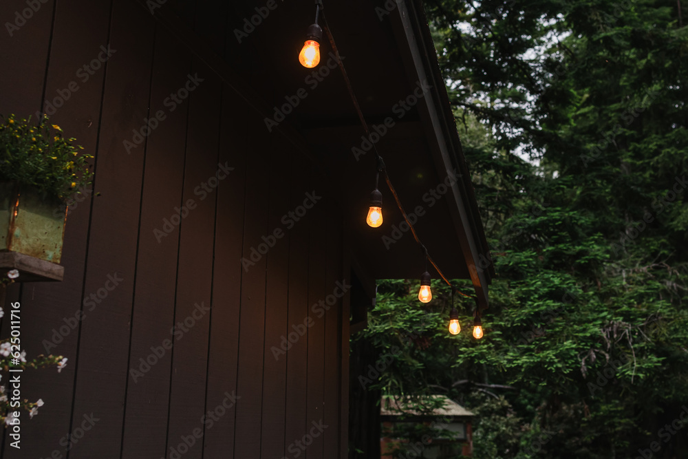 Outdoor garland with warm light the patio of wooden cabin Outdoor garland with warm light the patio of wooden cabin