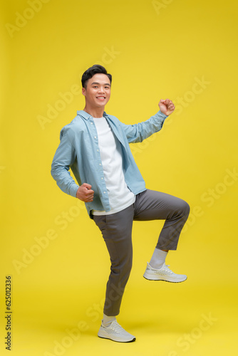  Portrait of young male cheerful confident and excited jump in air and smile at studio.