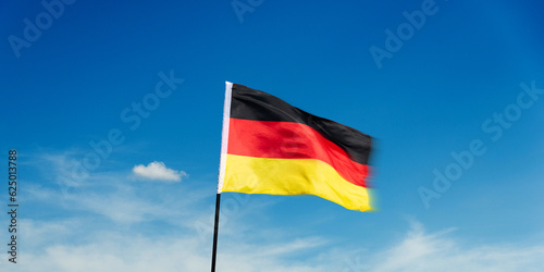 German flag waving against blue sky background
