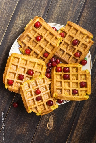 Dish with delicious Belgian waffles on a wooden background, close-up.