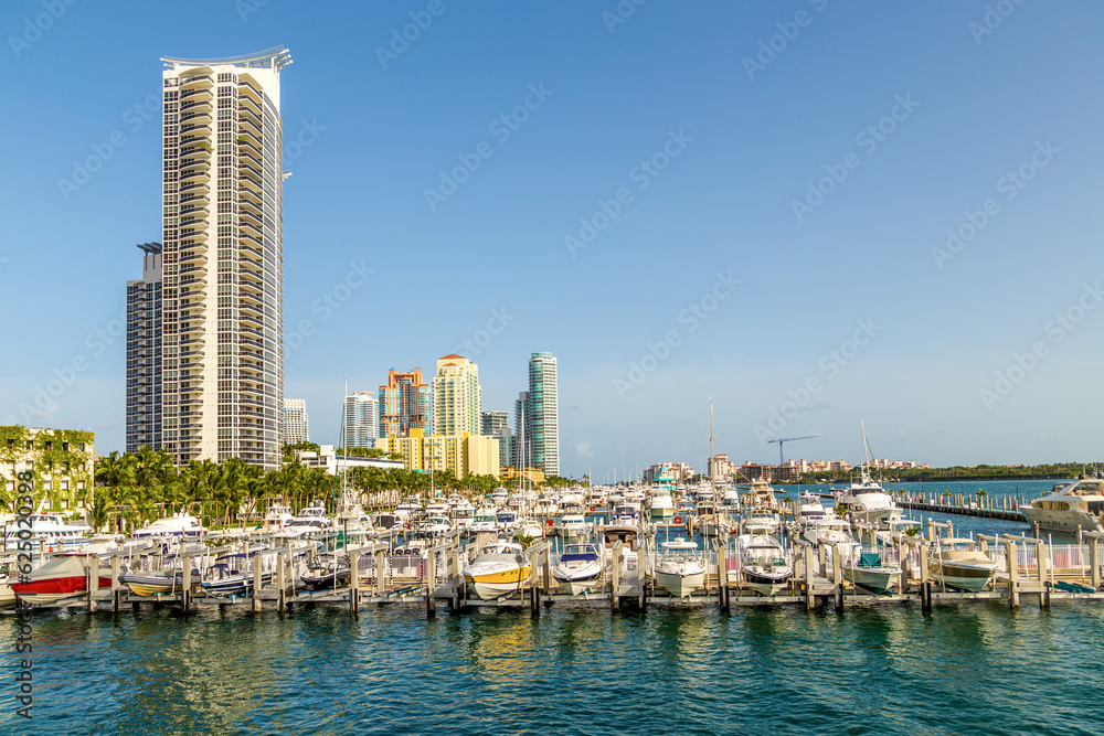 Miami skyline at daytime with blue sky and view to pier with motor boats