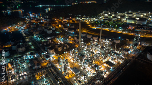 Oil refinery plant industry factory zone, oil and gas petrochemical industrial, oil storage tank and pipeline steel at night scene shot, aerial view