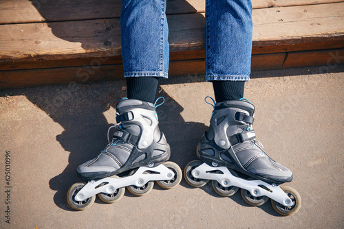 Young woman with roller skates in park. Rollerblading. Legs wearing roller skating shoe. Sport lifestyle.