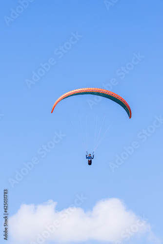 Paraglider flying above the clouds