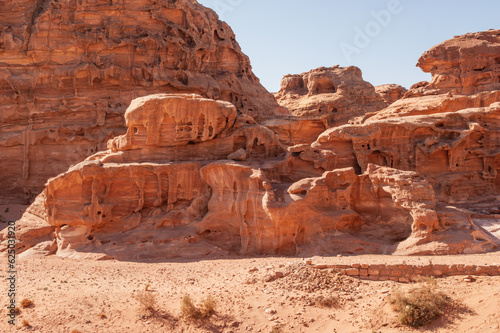 Jordan, Petra, Narrow road to Ad Deir monastery. Blurred background. Selective focus. Mountain landscapes with steep abysses. Road between rocks going up. Rocky rocks of red, pink and orange tones. © AlexanderDenisenko