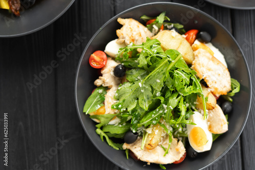 Obraz na płótnie Fried chicken fillet and salad of arugula, tomatoes, olives and garlic sauce