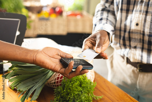 Senior african american man paying with credit card at health food organic grocery shop