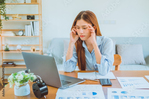 Asian young woman working from home using computer and drinking coffee in her room document finance and conference online meeting for new projects