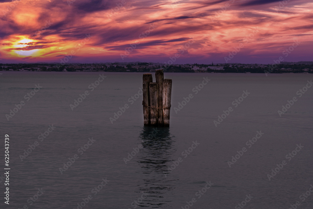wooden palisade in lake garda at sunset