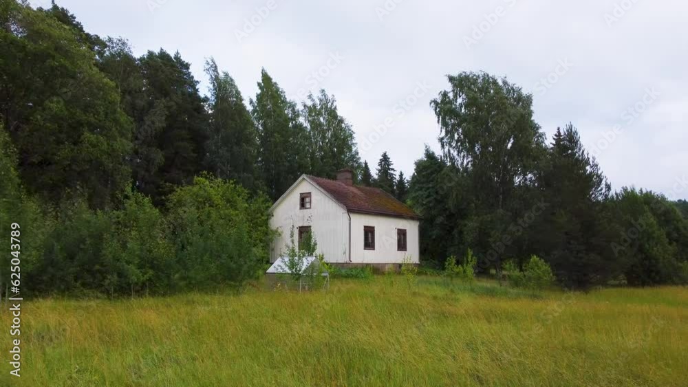 Abandoned house on the edge of the field on a cloudy evening. Establishing drone shot Abandoned house on the edge of the field on a cloudy evening. Establishing drone shot