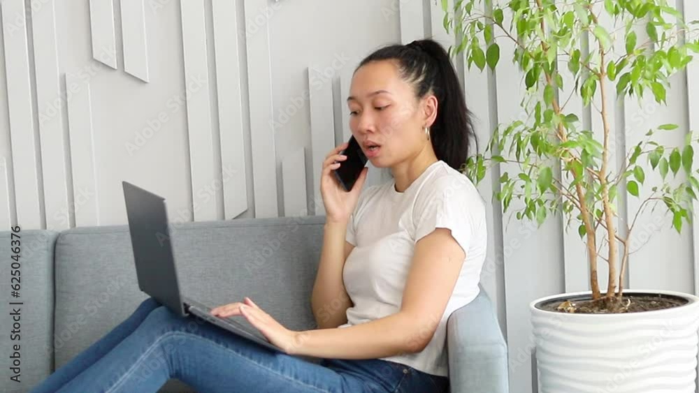 Asian girl freelancing remotely at home on the couch Asian girl freelancing remotely at home on the couch