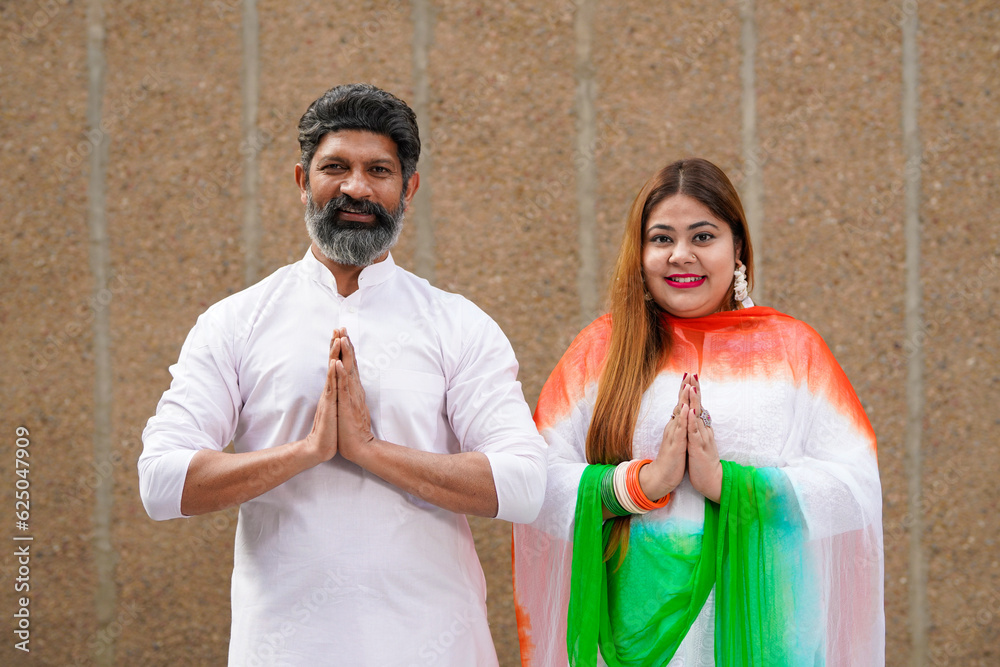 Indian couple giving namaste or welcome gesture.