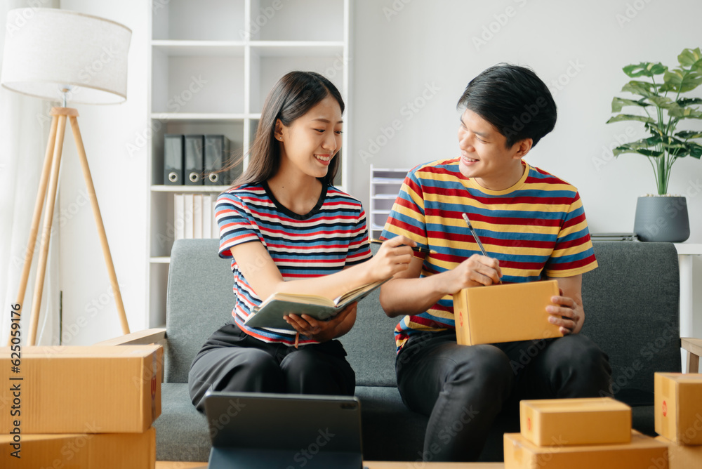young Asian man and woman at office of their business online shopping.In home office. young Asian man and woman at office of their business online shopping.In home office.