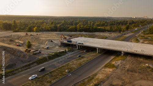 Evening with sunset light top view of a road construction site overlooking the forest and the city