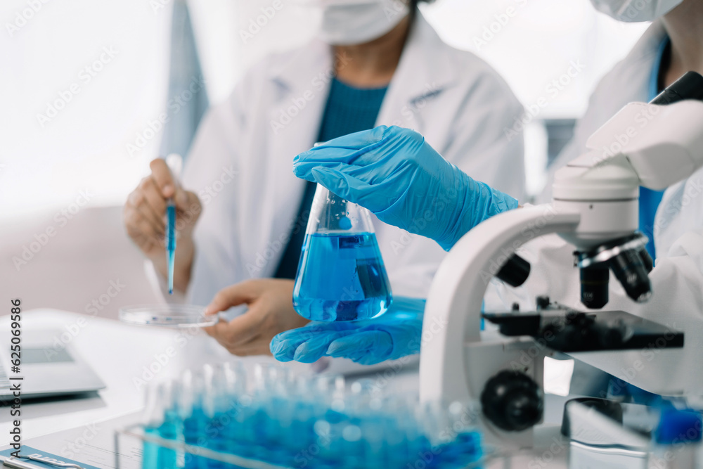 Scientist works with a pipette and a test tube. Scientific laboratory of biotechnology, development of medicine and research in chemistry, biochemistry and experiments. Scientist works with a pipette and a test tube. Scientific laboratory of biotechnology, development of medicine and research in chemistry, biochemistry and experiments.