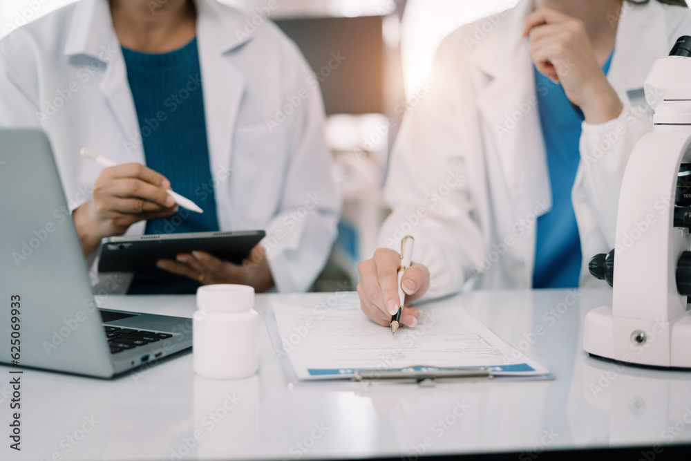 Medical Research Laboratory: Two scientists working, using digital tablets, analyzing samples, talking, developing biotechnology. Medical Research Laboratory: Two scientists working, using digital tablets, analyzing samples, talking, developing biotechnology.