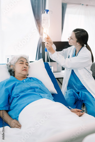 Professional doctor wear white coat uniform checking saline bag for patient at hospital room. Physician elderly care drip fluid saline bottle. Health care concept.