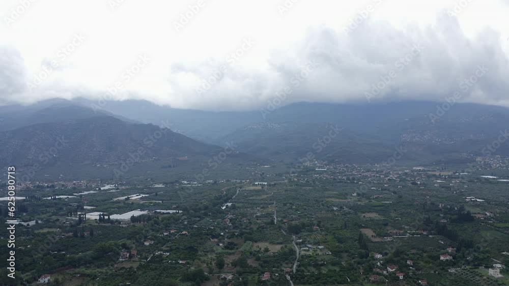 Misty overcast aerial rises over green agriculture fields in Greece Misty overcast aerial rises over green agriculture fields in Greece
