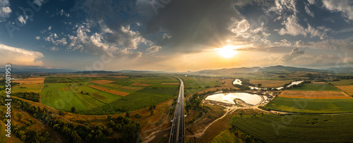 Fototapeta Naklejka Na Ścianę i Meble -  Aerial panoramic photo from above with A1 highway road between Sebes and Deva. Drone photo with the roads of Romania. Aerial view during sunset after a summer storm.